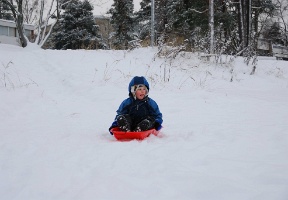 Antti sledding down a hill to the ice (that's covering the sea)