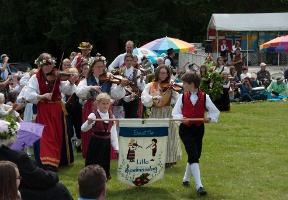 Music and dance groups march into the area before the majstång (midsummer pole) is raised
